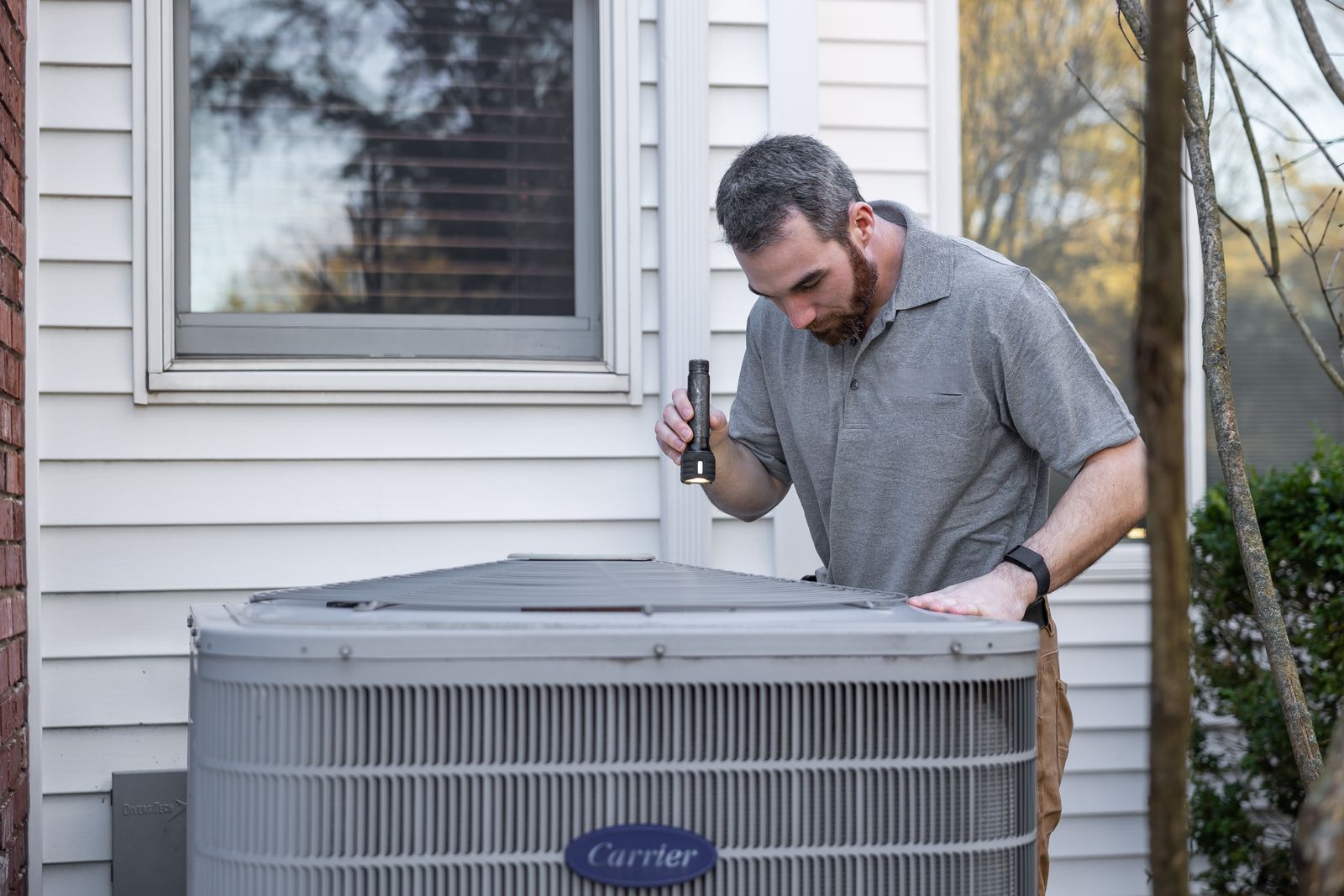 JVG technician inspecting a home air conditioning unit
